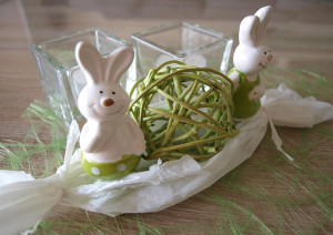 Zwei Porzellan-Osterhasen im Papier-Nest